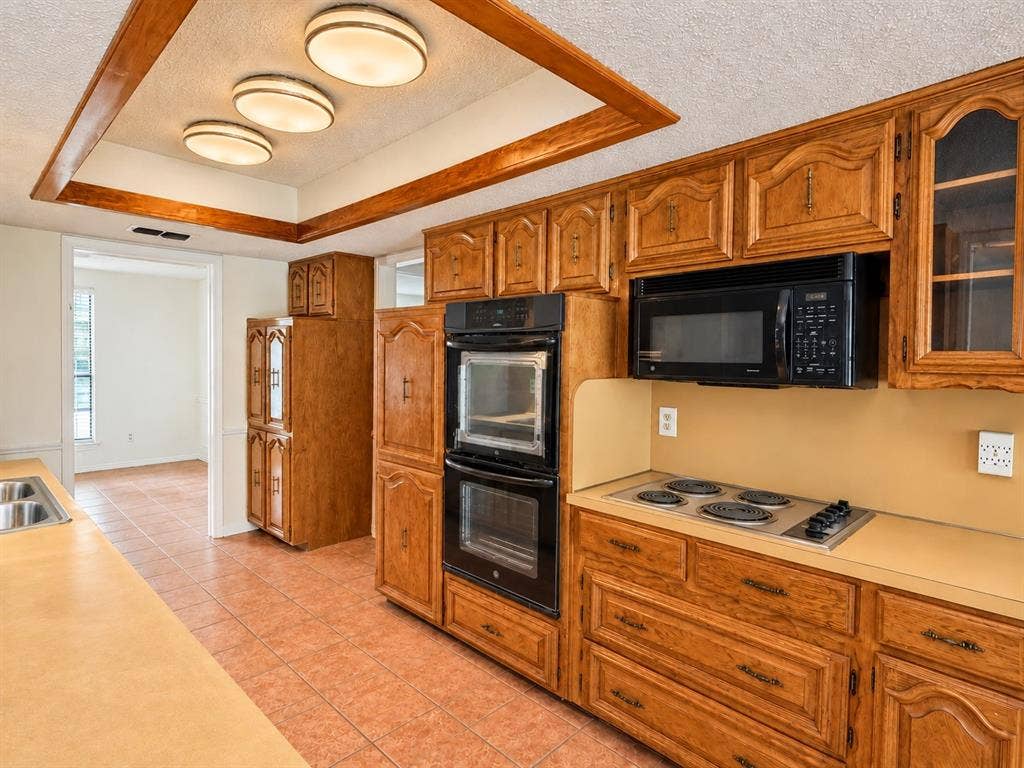 1444 Marlene Place, DeSoto, TX 75115 Kitchen featuring wood cabinetry, integrated double ovens, an electric cooktop, a built-in microwave, and tile flooring