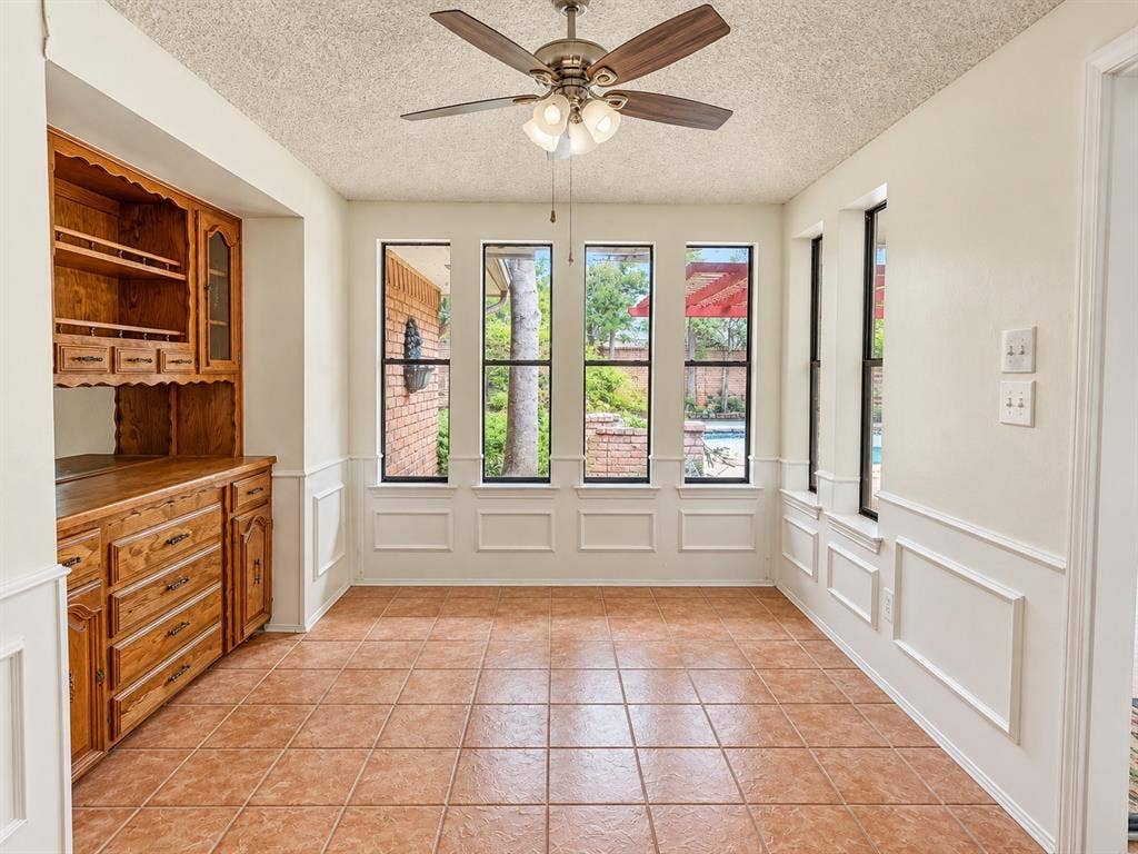 1444 Marlene Place, DeSoto, TX 75115 Built-in wood cabinetry with glass-front display, tile flooring, and multiple windows with white trim