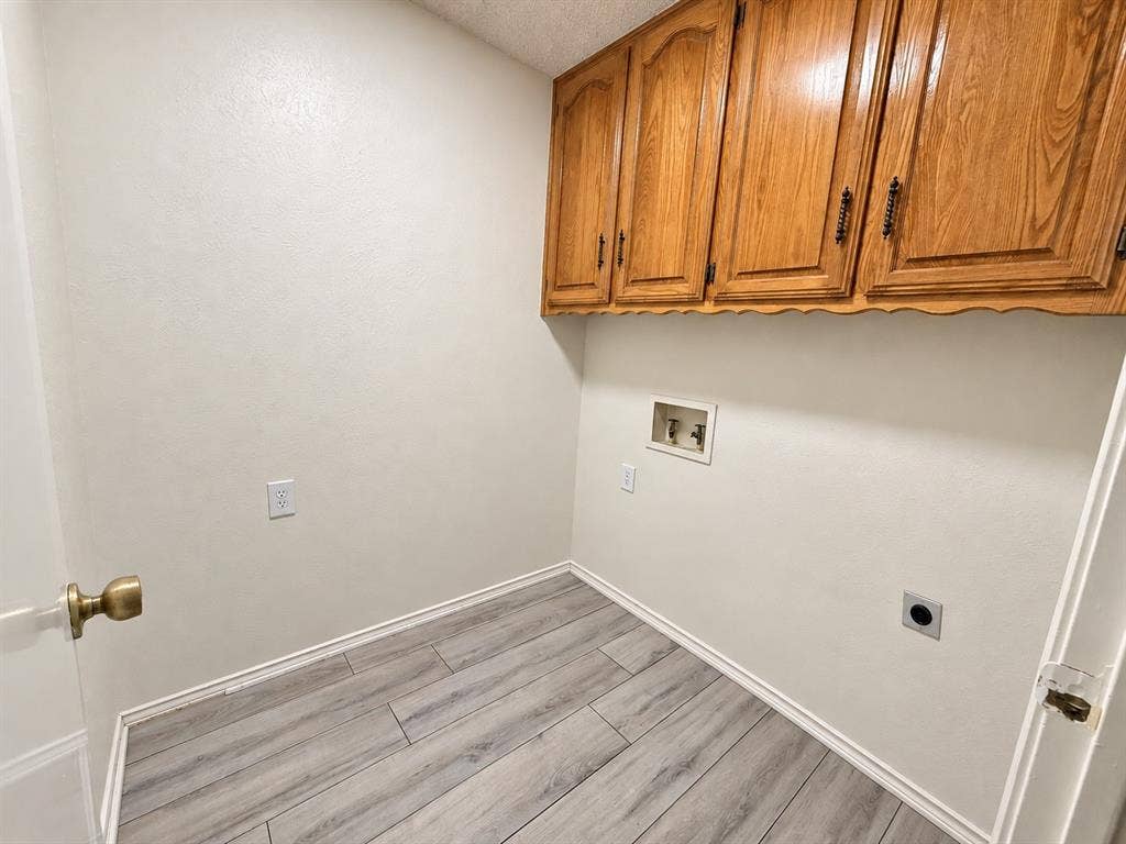 1444 Marlene Place, DeSoto, TX 75115 Wood-finish flooring, overhead cabinetry, and laundry hookups
