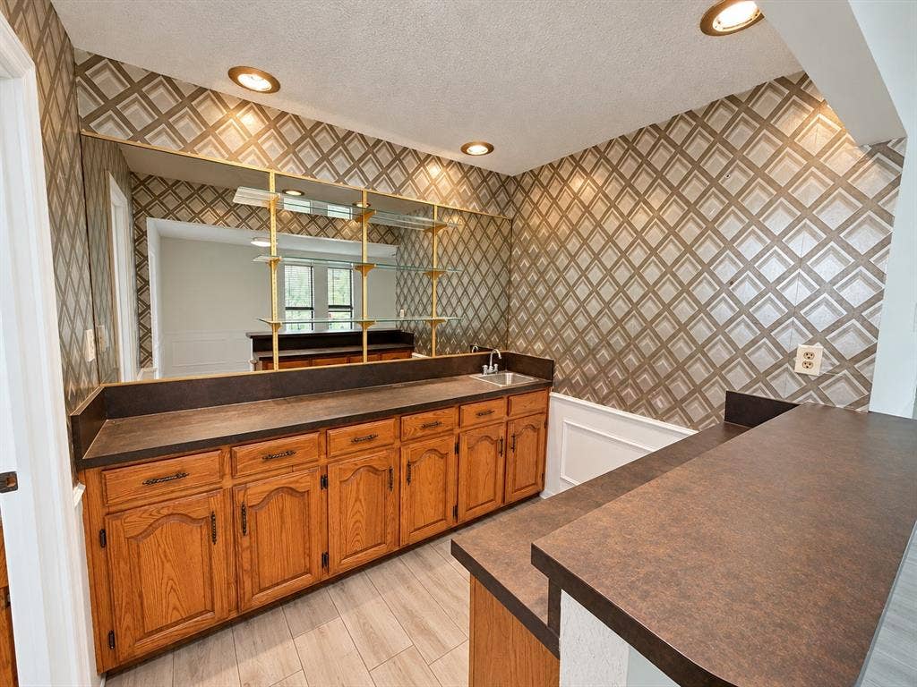 1444 Marlene Place, DeSoto, TX 75115 Built-in wet bar featuring wood cabinetry, integrated sink, and an expansive countertop