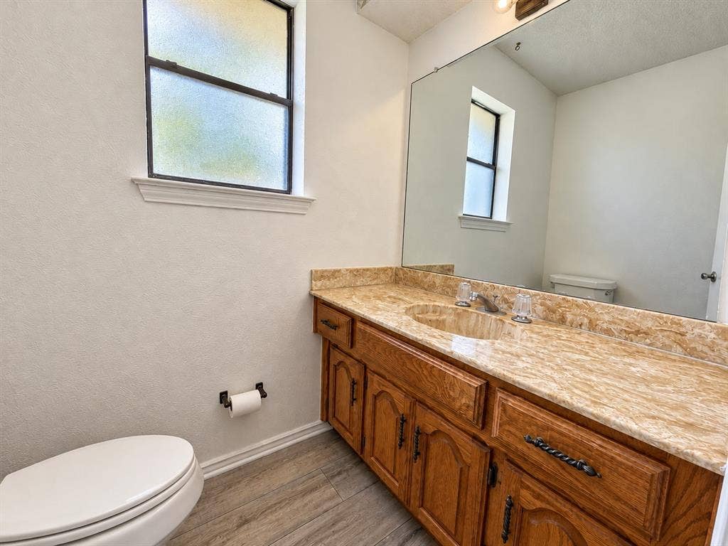 1444 Marlene Place, DeSoto, TX 75115 Dual sink vanity with wood cabinetry, light-toned countertop, and chrome fixtures