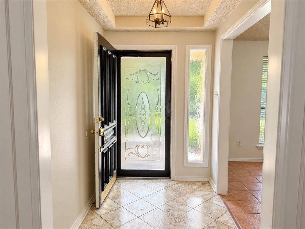 1444 Marlene Place, DeSoto, TX 75115 Entryway featuring a decorative glass front door with a sidelight, tiled flooring, and a coffered ceiling with a mounted light fixture