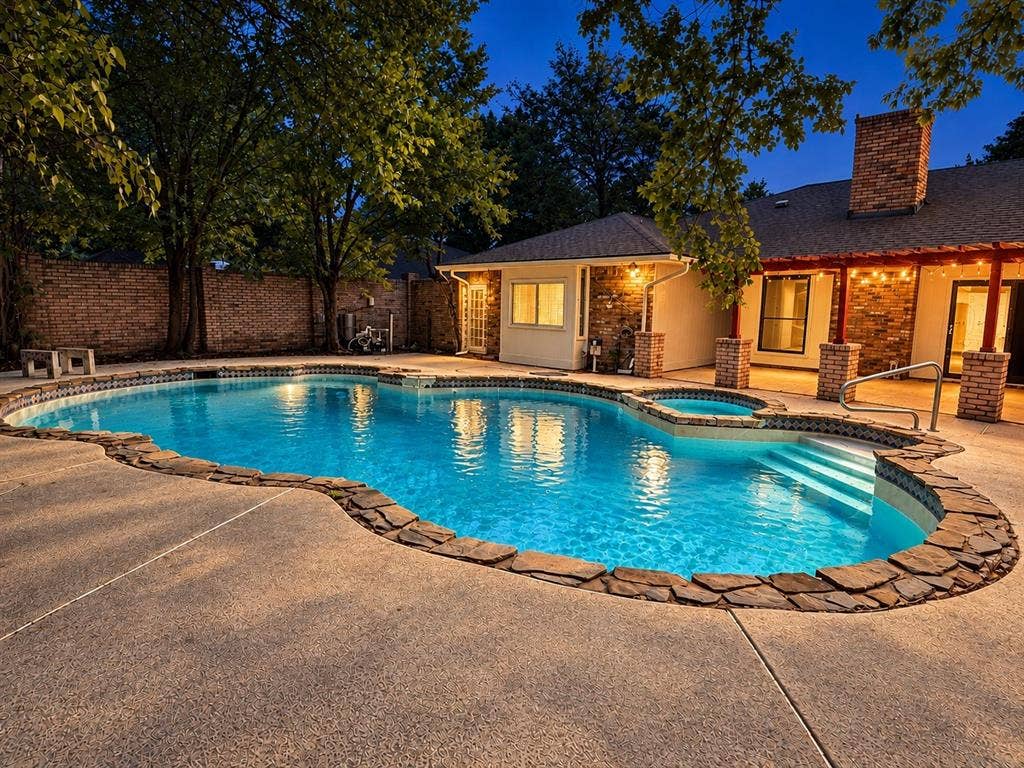 1444 Marlene Place, DeSoto, TX 75115 Kidney-shaped swimming pool with an integrated spa, stone coping, and concrete decking