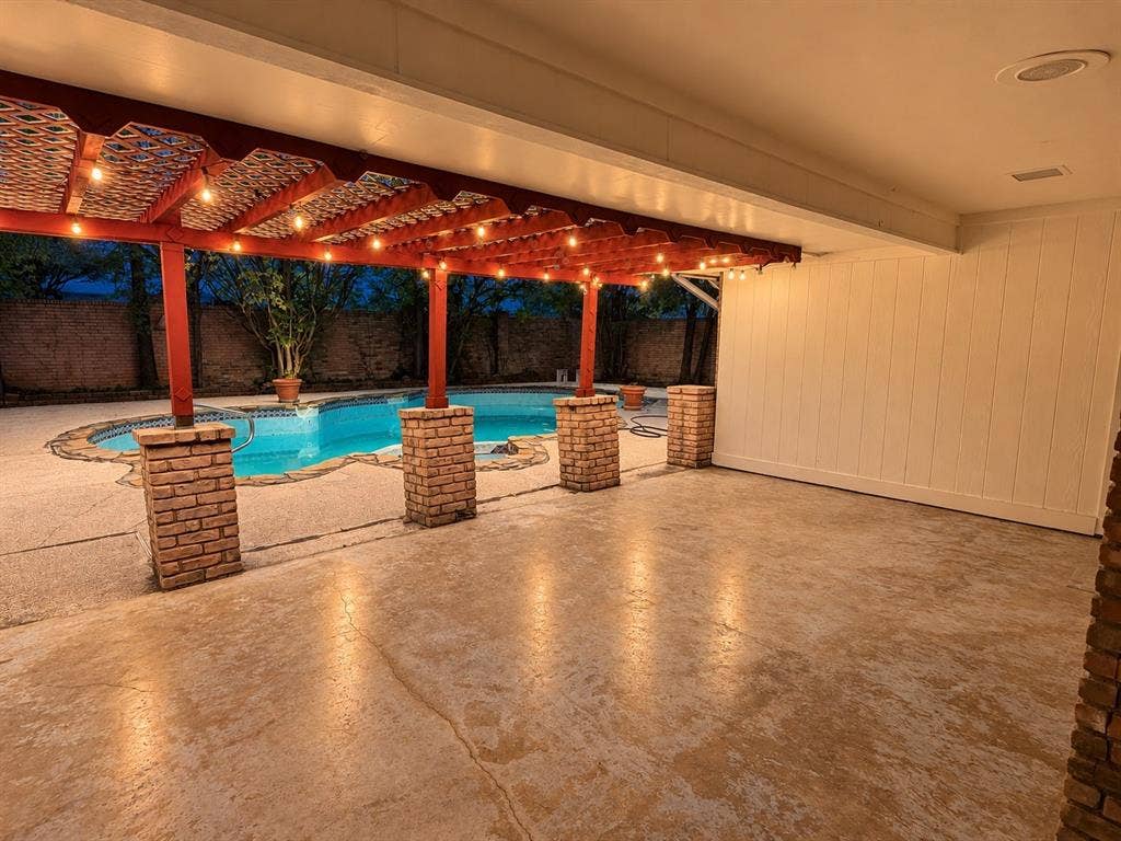 1444 Marlene Place, DeSoto, TX 75115 Patio with a large swimming pool, brick-clad support columns, and an expansive covered area featuring a red wood-finish pergola
