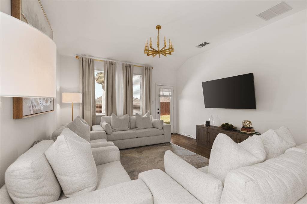 1456 Martingale Lane, Forney, TX 75126 Vaulted ceilings, wood-finish flooring, gold-tone chandelier, and natural light from tall windows