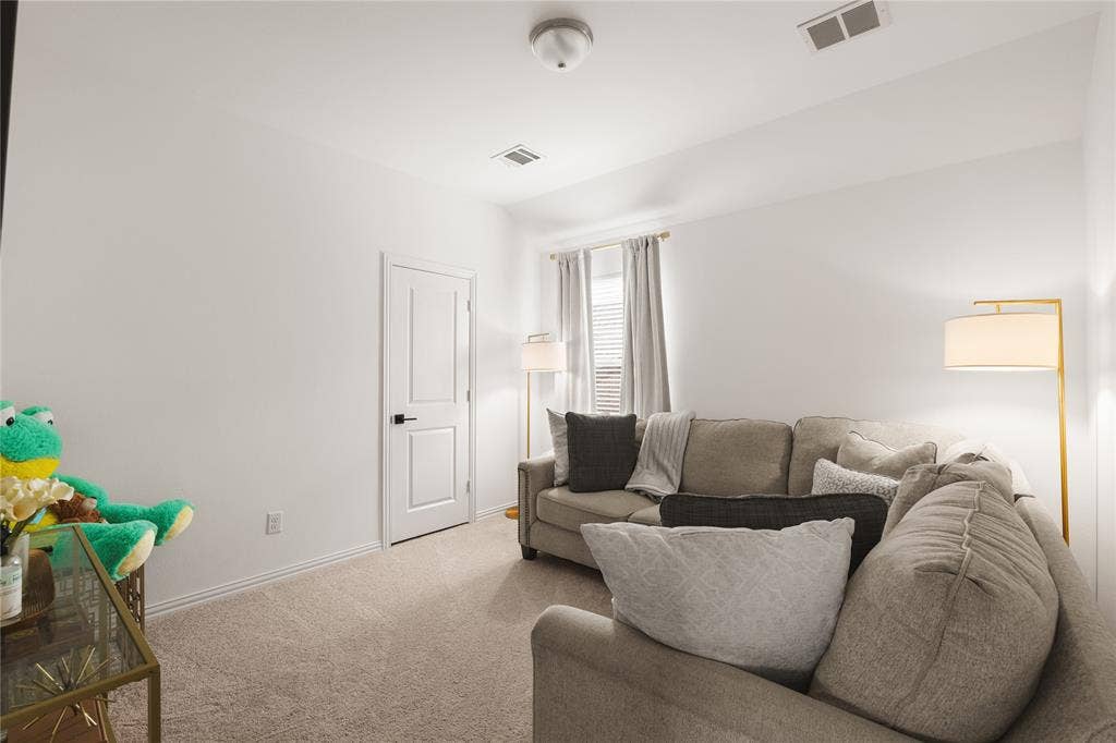 1456 Martingale Lane, Forney, TX 75126 Neutral-toned carpeted flooring, white walls, and a single-panel interior door featuring a matte black handle