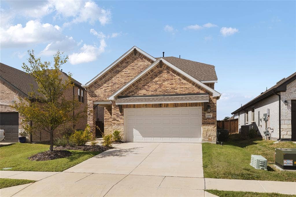 1456 Martingale Lane, Forney, TX 75126 Brick and stone masonry facade with a covered entryway and attached two-car garage