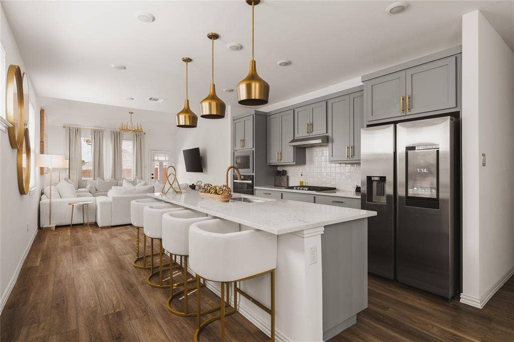 1456 Martingale Lane, Forney, TX 75126 Kitchen featuring gray shaker-style cabinetry, quartz countertops, an expansive center island, wood-finish flooring, and metallic pendant lighting