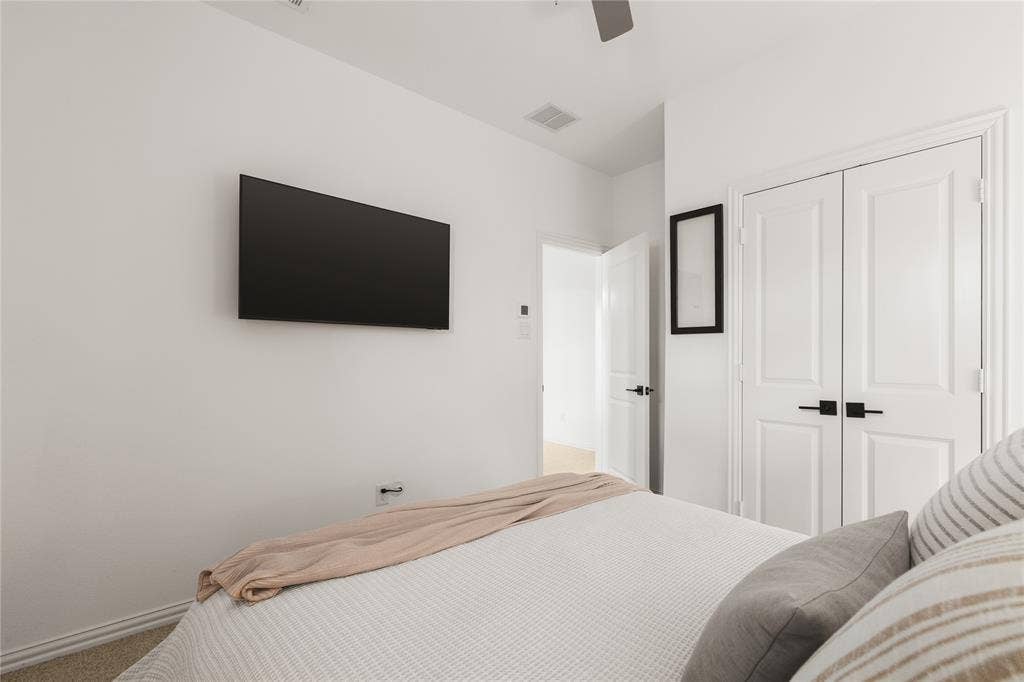1456 Martingale Lane, Forney, TX 75126 Interior room featuring neutral wall paint, carpet flooring, a ceiling fan, and double-panel closet doors with matte black hardware