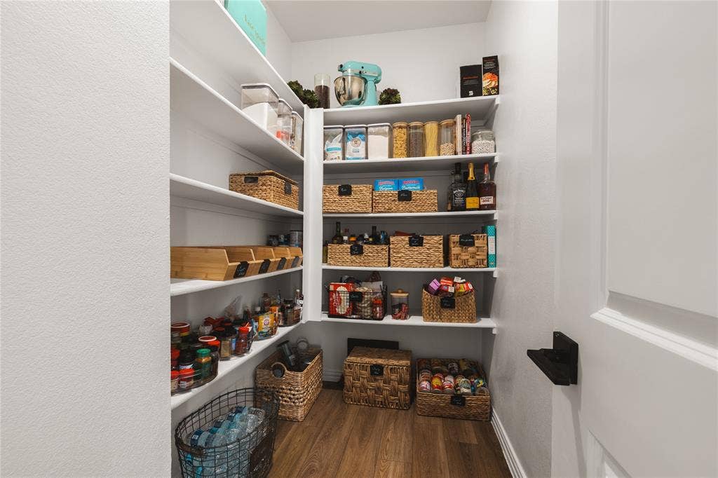 1456 Martingale Lane, Forney, TX 75126 Walk-in pantry featuring white wrap-around shelving and wood-finish flooring
