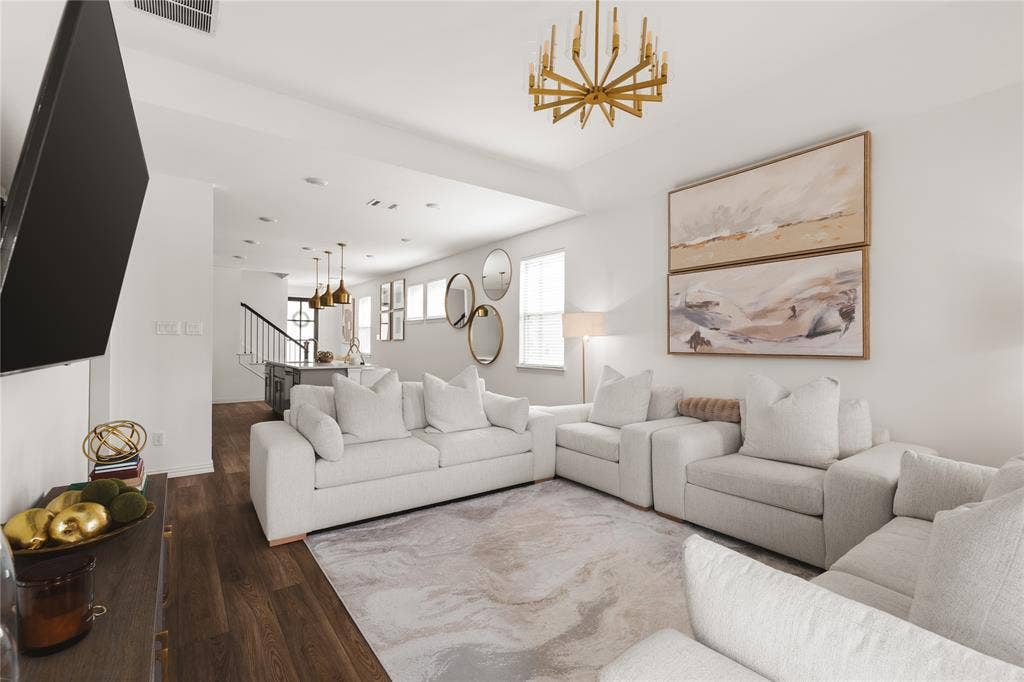 1456 Martingale Lane, Forney, TX 75126 Open-concept living space featuring wood-finish flooring, a multi-arm metallic chandelier, recessed lighting, and a metal-railed staircase