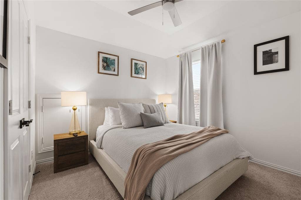1456 Martingale Lane, Forney, TX 75126 Neutral-toned carpeted flooring, multi-panel interior door with matte black hardware, and ceiling-mounted fan with light fixture