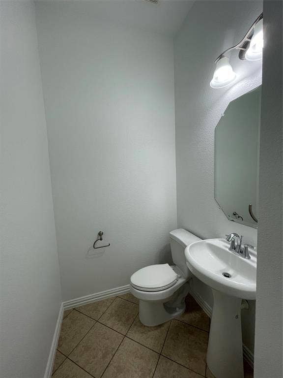 1944 Loma Linda Drive, Irving, TX 75063 Powder room featuring a porcelain pedestal sink, polished chrome faucet, diamond-pattern tile flooring, and a wall-mounted vanity light fixture