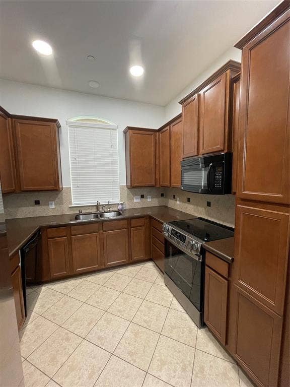 1944 Loma Linda Drive, Irving, TX 75063 Kitchen featuring wood cabinetry, solid surface countertops, a tiled backsplash, ceramic tile flooring, and integrated stainless steel appliances