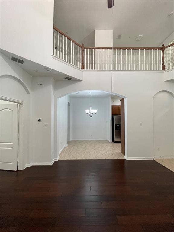 1944 Loma Linda Drive, Irving, TX 75063 Two-story height ceiling with mezzanine landing, dark wood-finish flooring, arched architectural entries, tile flooring in supplemental area, and baluster railing
