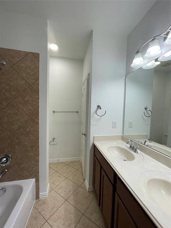 1944 Loma Linda Drive, Irving, TX 75063 Dual-sink vanity with a solid-surface countertop, diamond-patterned ceramic tile flooring, and a shower-tub combination featuring tiled wall surrounds