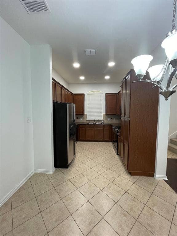1944 Loma Linda Drive, Irving, TX 75063 Kitchen featuring dark wood cabinetry, tile flooring laid on a diagonal, stainless steel refrigerator, recessed lighting, and a multi-arm chandelier