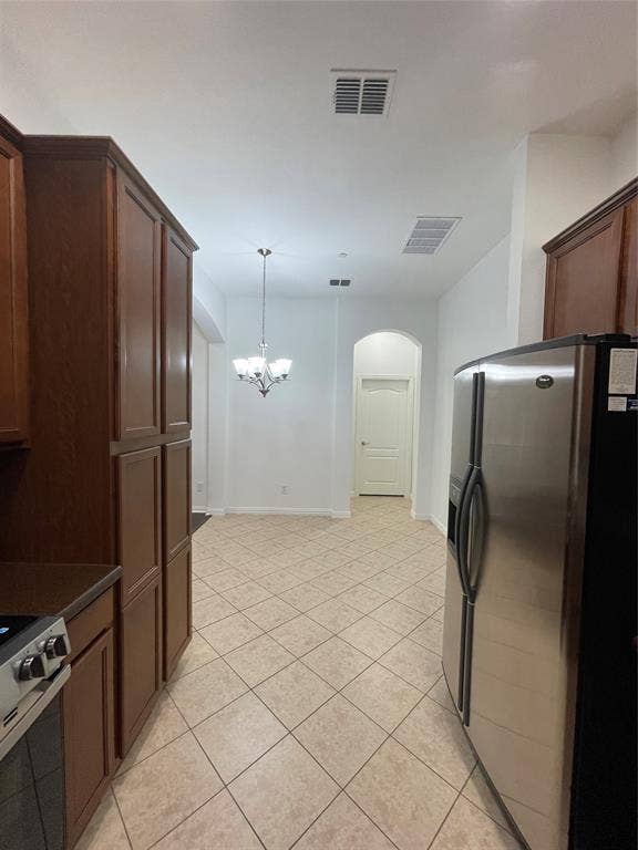 1944 Loma Linda Drive, Irving, TX 75063 Kitchen featuring dark wood-finish cabinetry, stainless steel side-by-side refrigerator, tile flooring laid on a diagonal, and an arched doorway