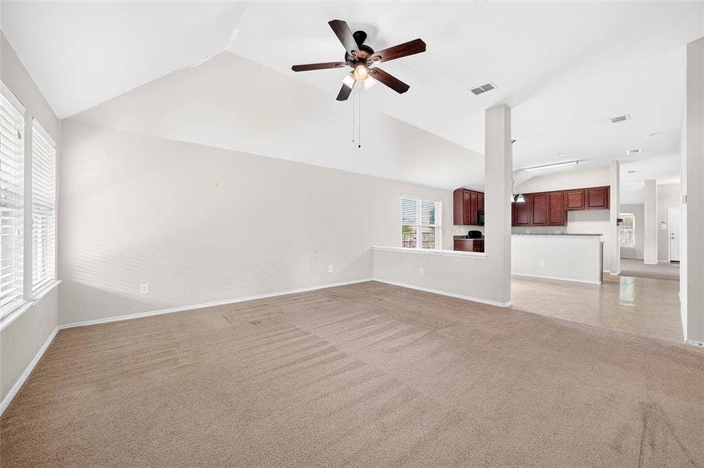 8448 Little Fawn Lane, Dallas, TX 75249 Vaulted ceilings, carpeted flooring, built-in ceiling fan with integrated lighting, wood-finish cabinetry, and solid surface kitchen countertops