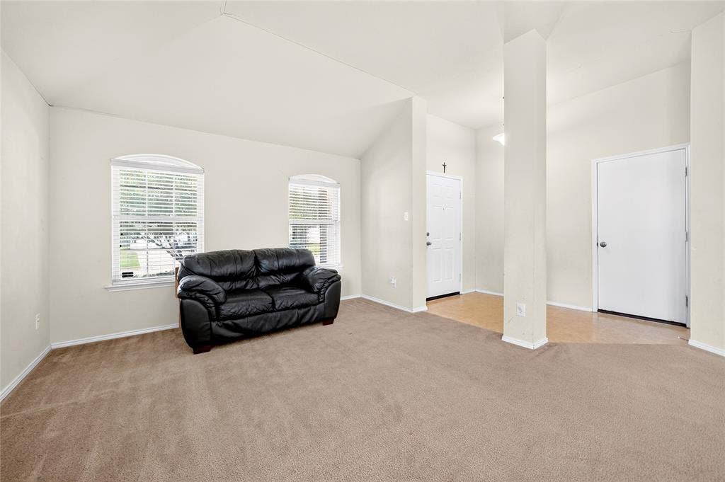 8448 Little Fawn Lane, Dallas, TX 75249 Vaulted ceilings, arched windows with horizontal blinds, neutral wall-to-neutral wall carpeting, and tile flooring at the entry