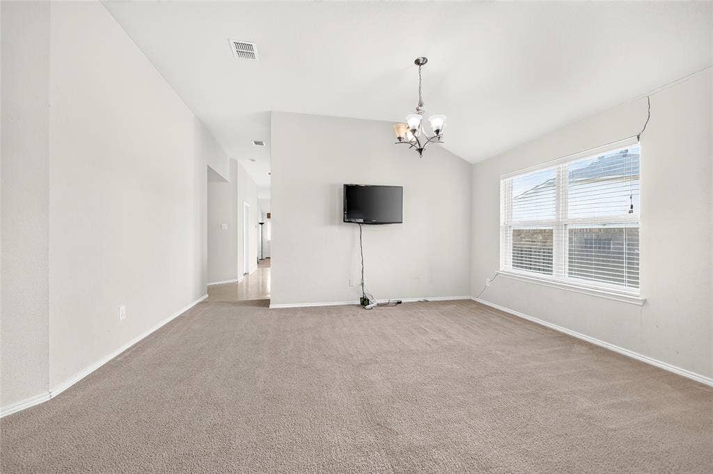 8448 Little Fawn Lane, Dallas, TX 75249 Vaulted ceilings, neutral carpeting, multi-pane window with blinds, and decorative chandelier lighting