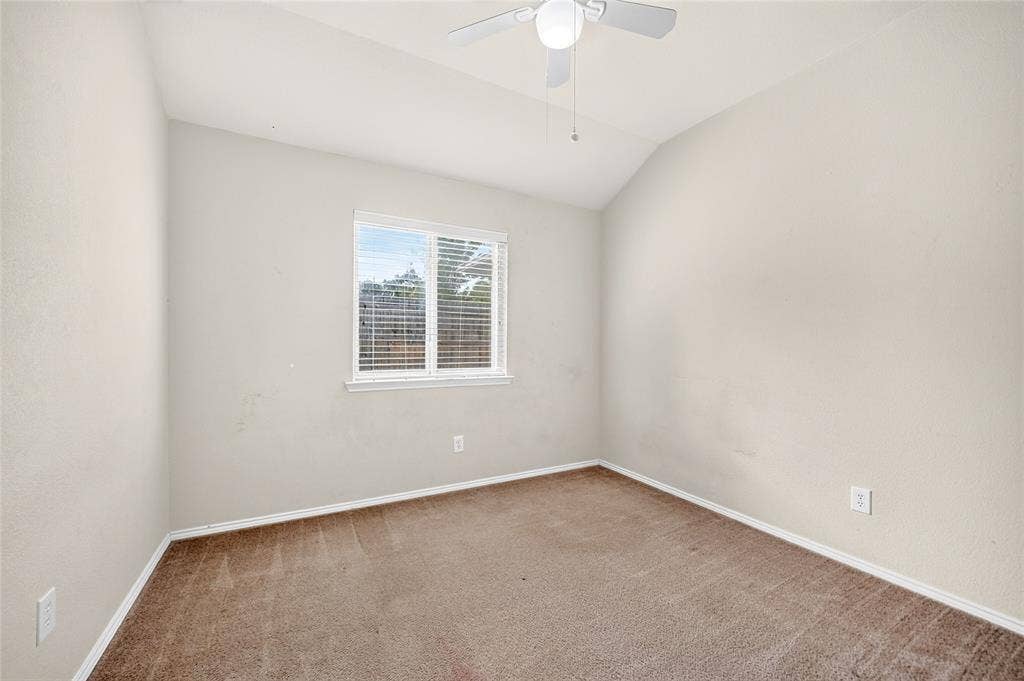 8448 Little Fawn Lane, Dallas, TX 75249 Interior space featuring vaulted ceilings, neutral wall tones, carpeted flooring, and a ceiling-mounted light fixture with fan