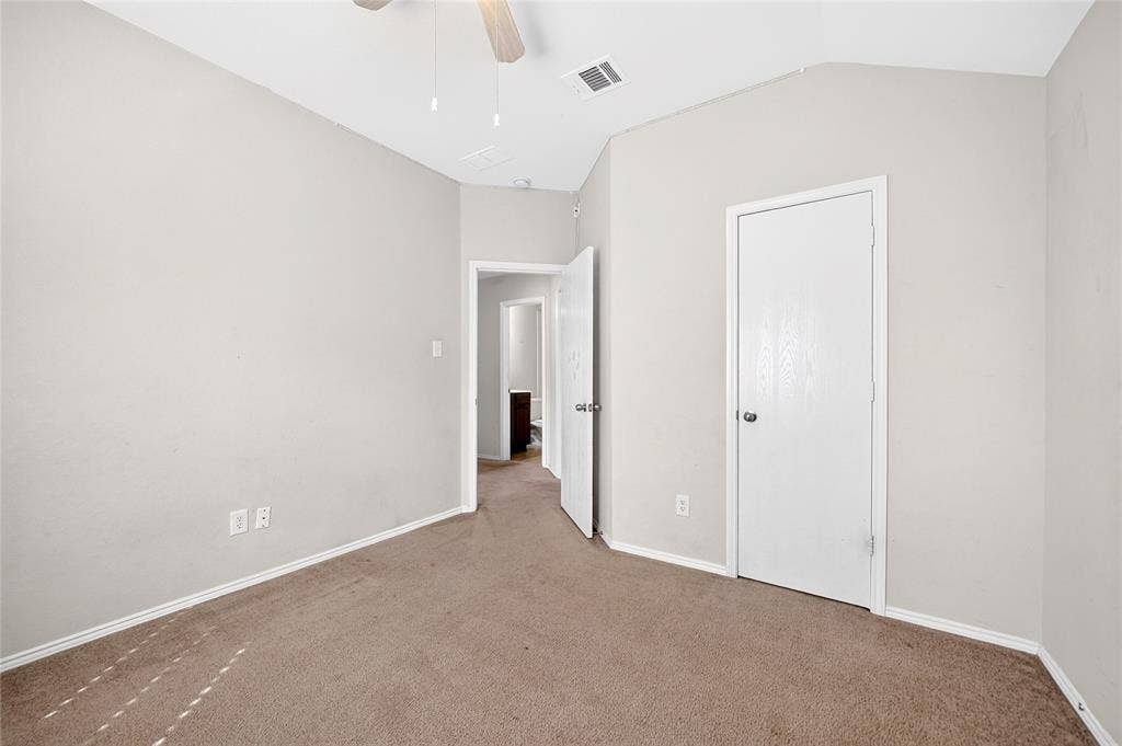 8448 Little Fawn Lane, Dallas, TX 75249 Room featuring a vaulted ceiling, neutral wall tones, carpeted flooring, and a single-panel interior door
