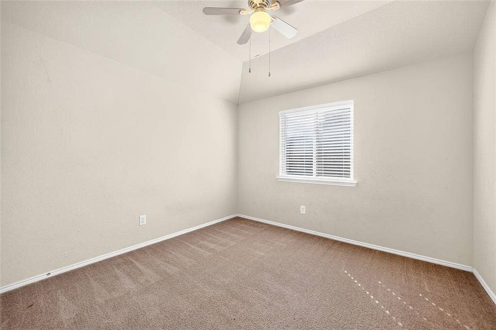 8448 Little Fawn Lane, Dallas, TX 75249 Vaulted ceiling, neutral wall tones, wall-to-wall carpeting, window with built-in blinds, and a ceiling fan with integrated lighting