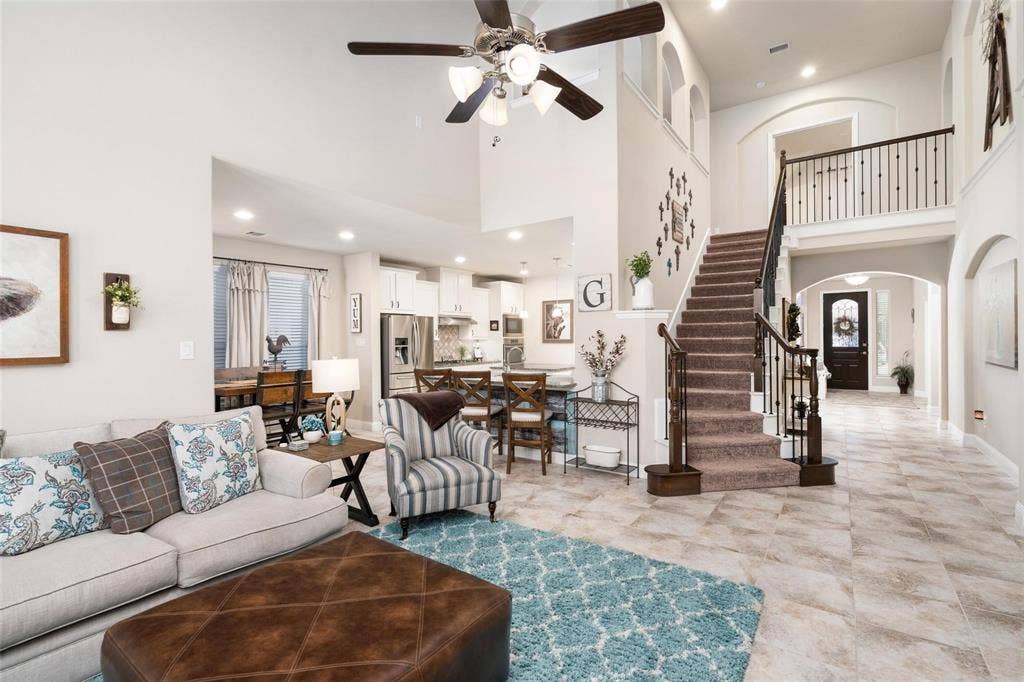 1017 Hoyt Drive, McKinney, TX 75071 Two-story foyer with tile flooring, grand staircase with wrought iron balusters, and arched doorways
