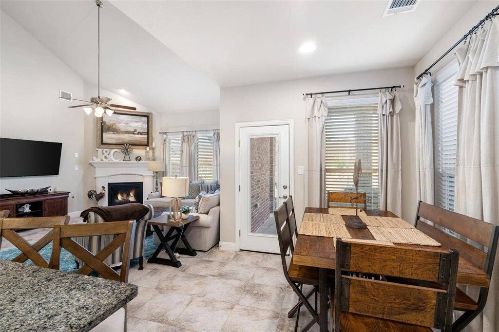 1017 Hoyt Drive, McKinney, TX 75071 Vaulted ceiling, recessed lighting, tile flooring, built-in fireplace, and a glass-paneled door
