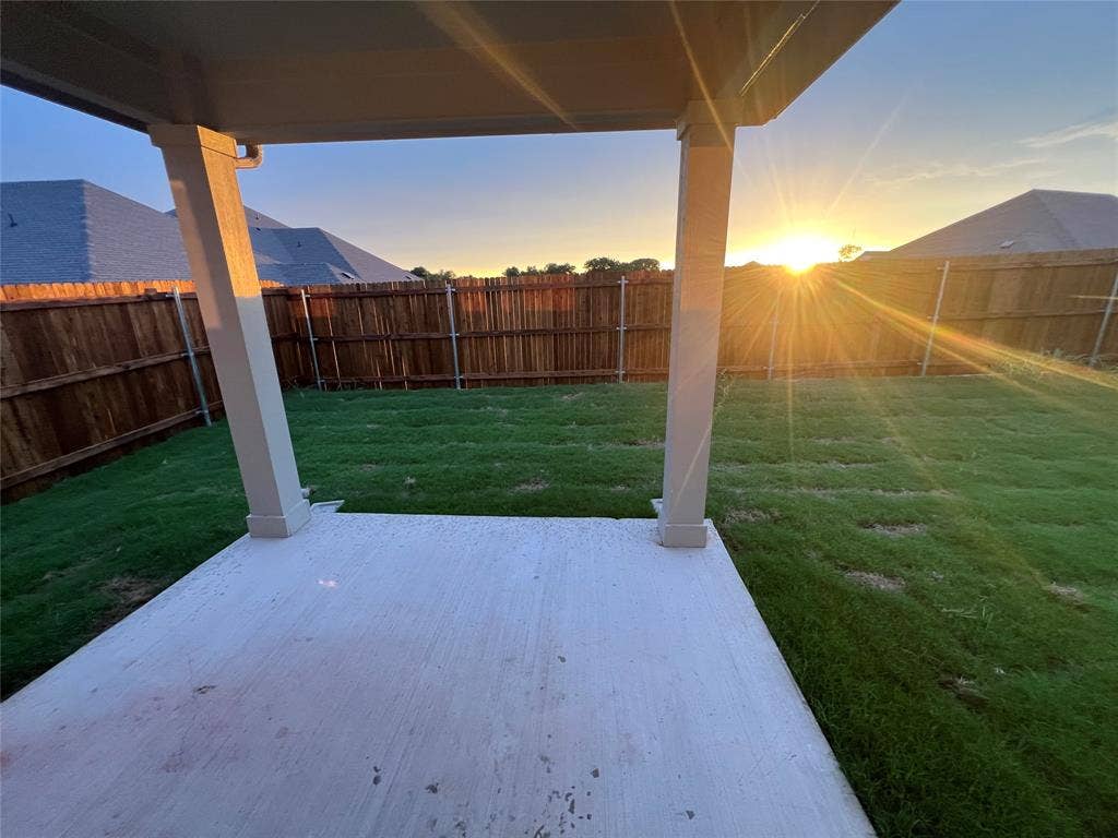 5908 Brittner Drive, Princeton, TX 75071 Covered patio with concrete flooring, private wood fencing, and a grassy lawn