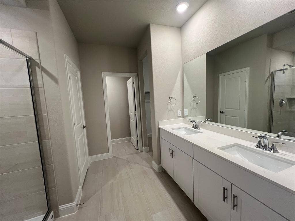 5908 Brittner Drive, Princeton, TX 75071 Dual vanity with integrated sinks, expansive mirror, recessed lighting, and tile flooring