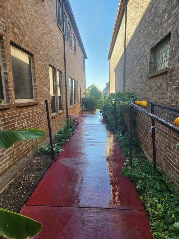 3038 Ivy Hill Lane, Irving, TX 75063 Brick exterior with multiple windows and a red-toned concrete pathway