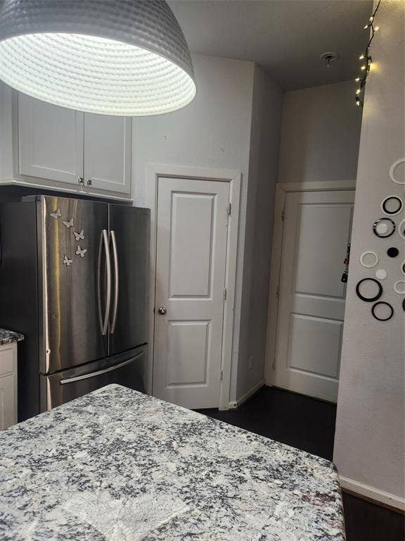 3038 Ivy Hill Lane, Irving, TX 75063 Stainless steel refrigerator, white shaker-style cabinetry, patterned countertop, dark wood-finish flooring