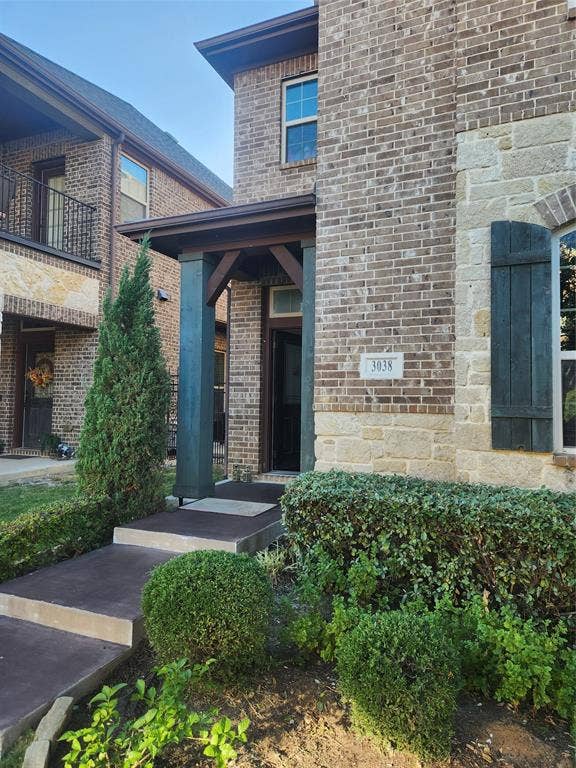 3038 Ivy Hill Lane, Irving, TX 75063 Brick exterior with stone accents, covered entry, and decorative window shutters
