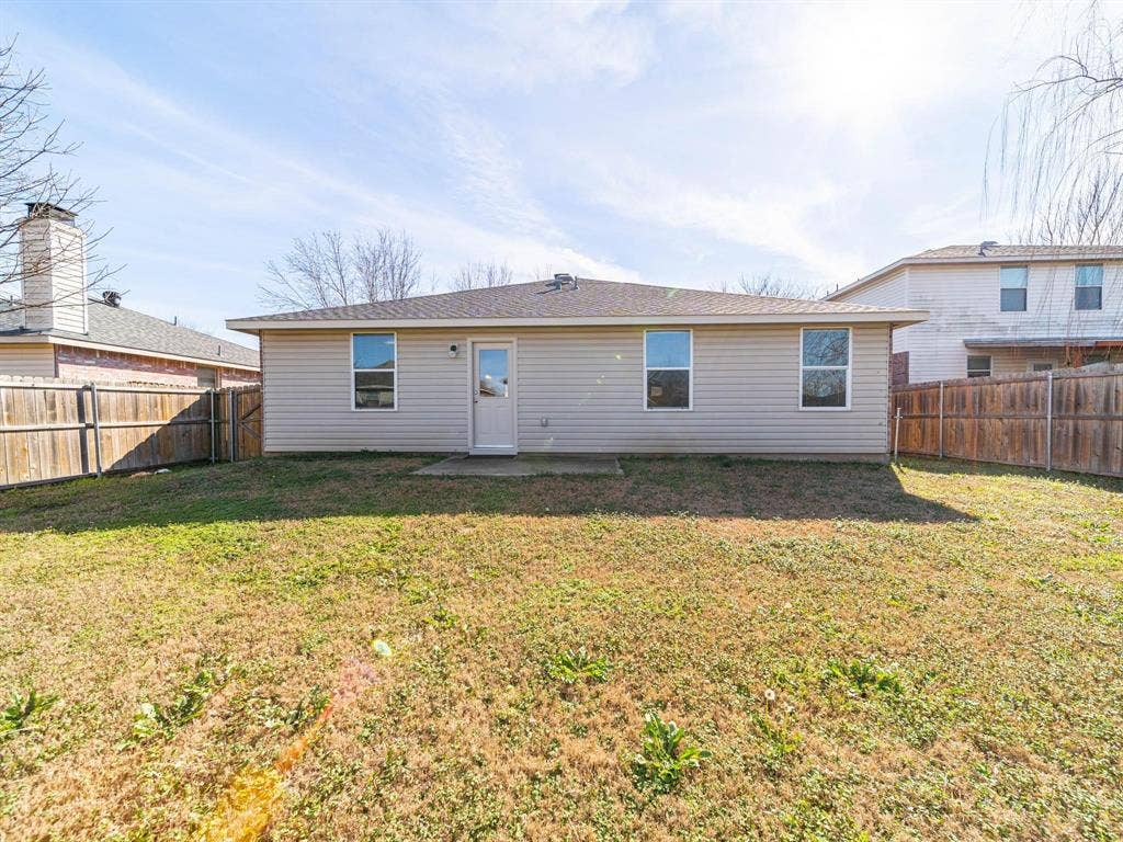 Expansive backyard with a wood privacy fence and a rear patio