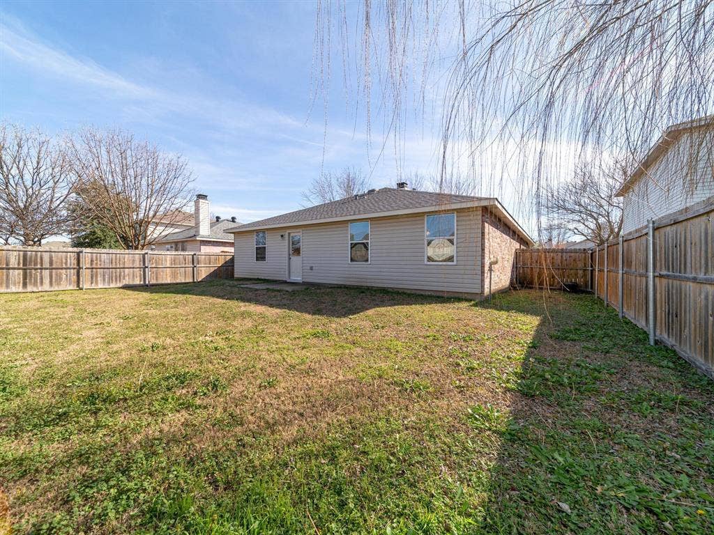 Expansive grassy yard with wood fencing and a concrete patio