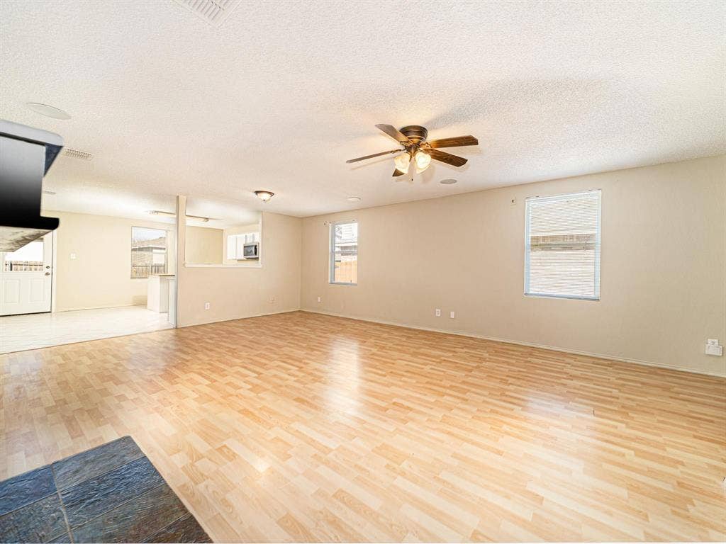 Spacious room with wood-finish flooring and neutral wall tones