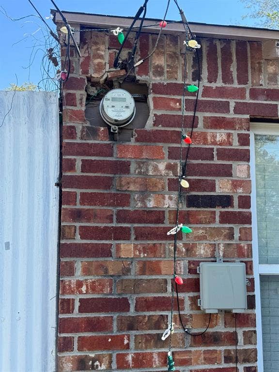 544 Pleasant Meadows Lane, Dallas, TX 75217 Close-up of the exterior brick wall and electric meter.