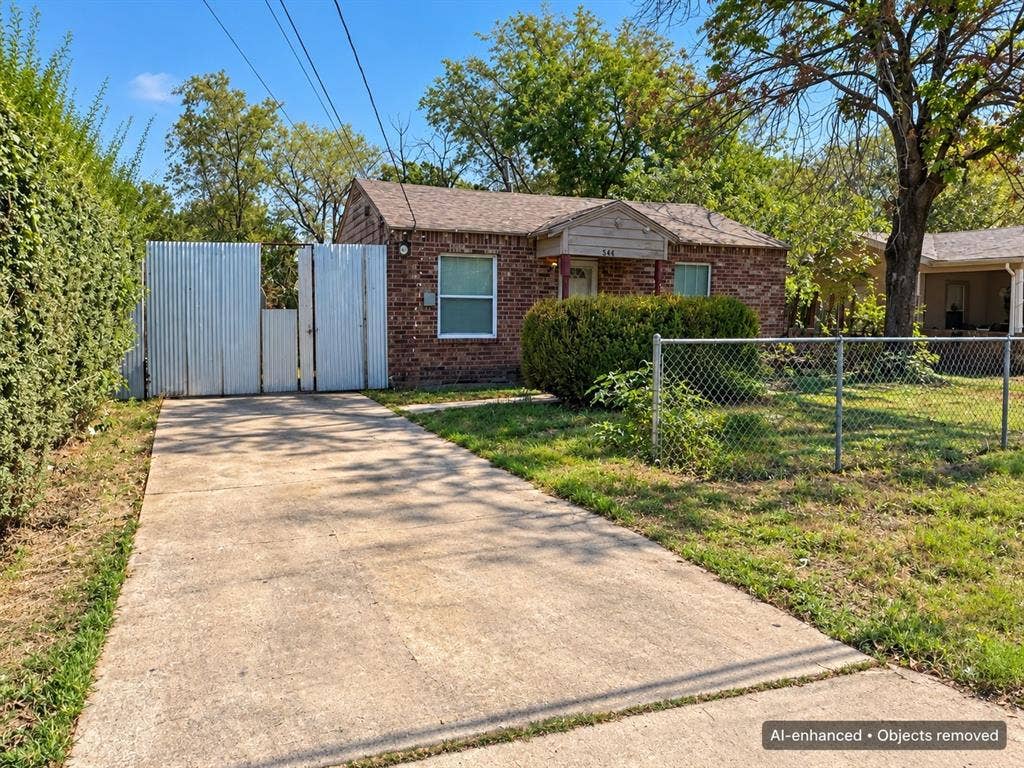 544 Pleasant Meadows Lane, Dallas, TX 75217 Single-story brick home featuring a concrete driveway, fenced front yard, and gated side access.