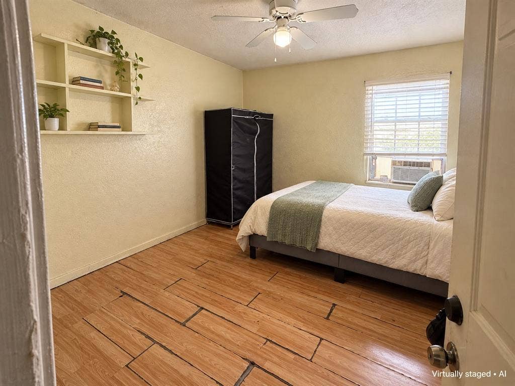 544 Pleasant Meadows Lane, Dallas, TX 75217 Bedroom featuring wood-look flooring, ceiling fan, and a window providing natural light. Virtually staged.