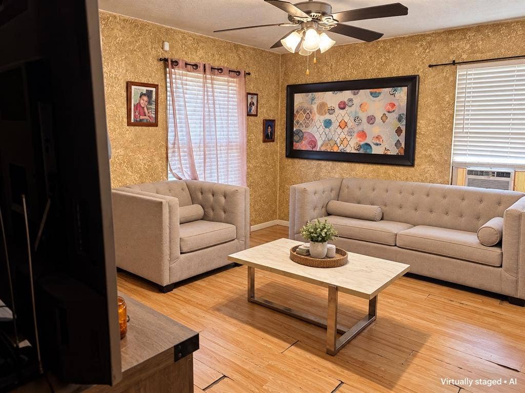 544 Pleasant Meadows Lane, Dallas, TX 75217 Living area featuring wood-look flooring, ceiling fan, and natural light. Virtually staged to showcase furniture placement possibilities.