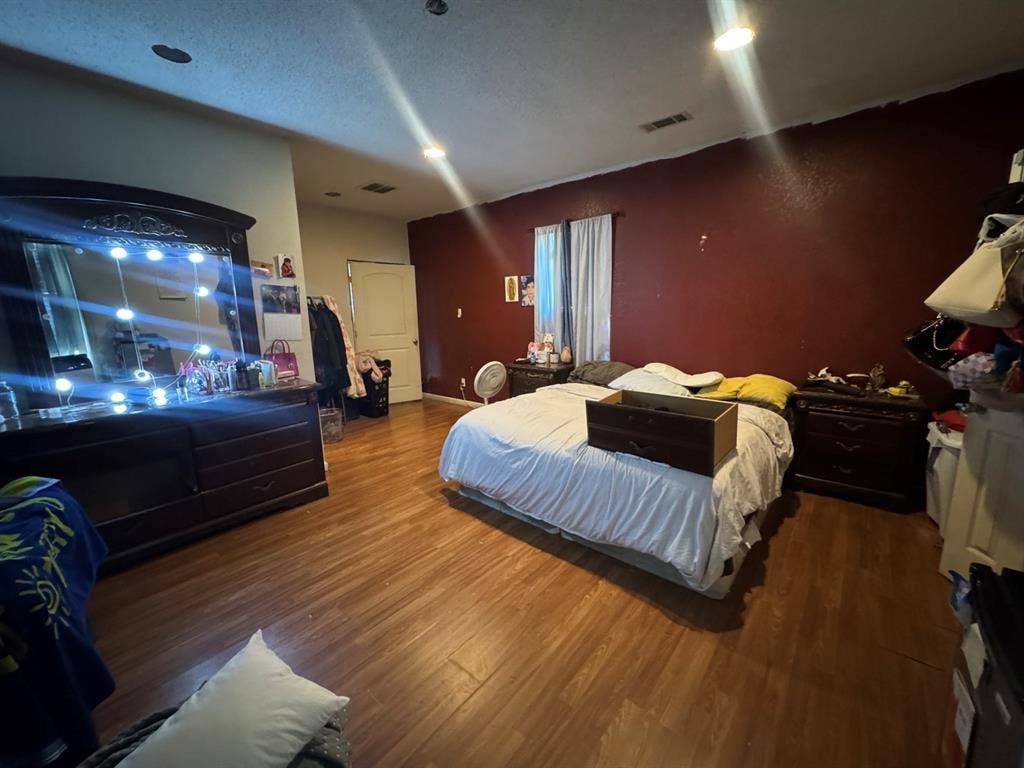 544 Pleasant Meadows Lane, Dallas, TX 75217 Spacious bedroom featuring wood-look flooring, recessed lighting, a contrasting accent wall, and room for additional furnishings.