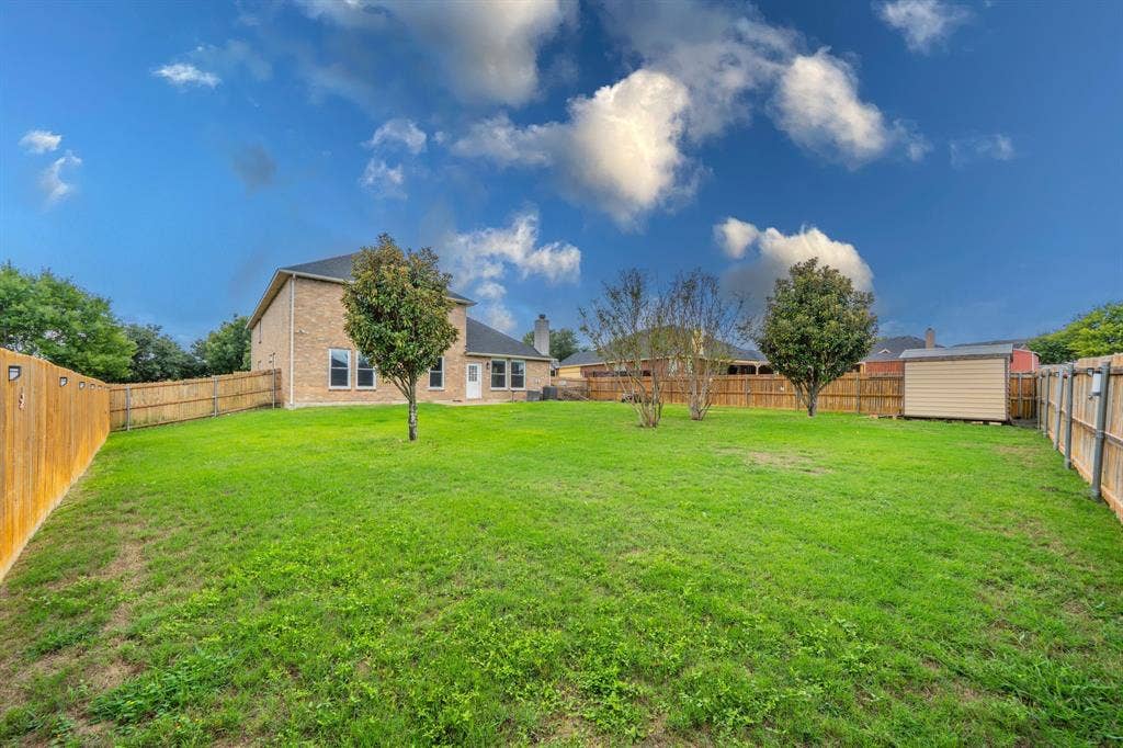 1739 Chadwick Drive, Cedar Hill, TX 75104 Backyard view of house, storage shed, wood privacy fence and large backyard.