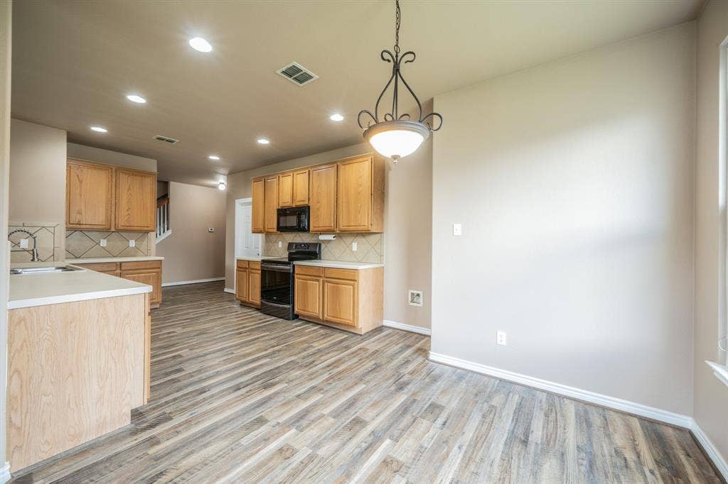1739 Chadwick Drive, Cedar Hill, TX 75104 Breakfast nook with decorative lighting, looking into the kitchen with built-in microwave, range and water line for refrigerator.