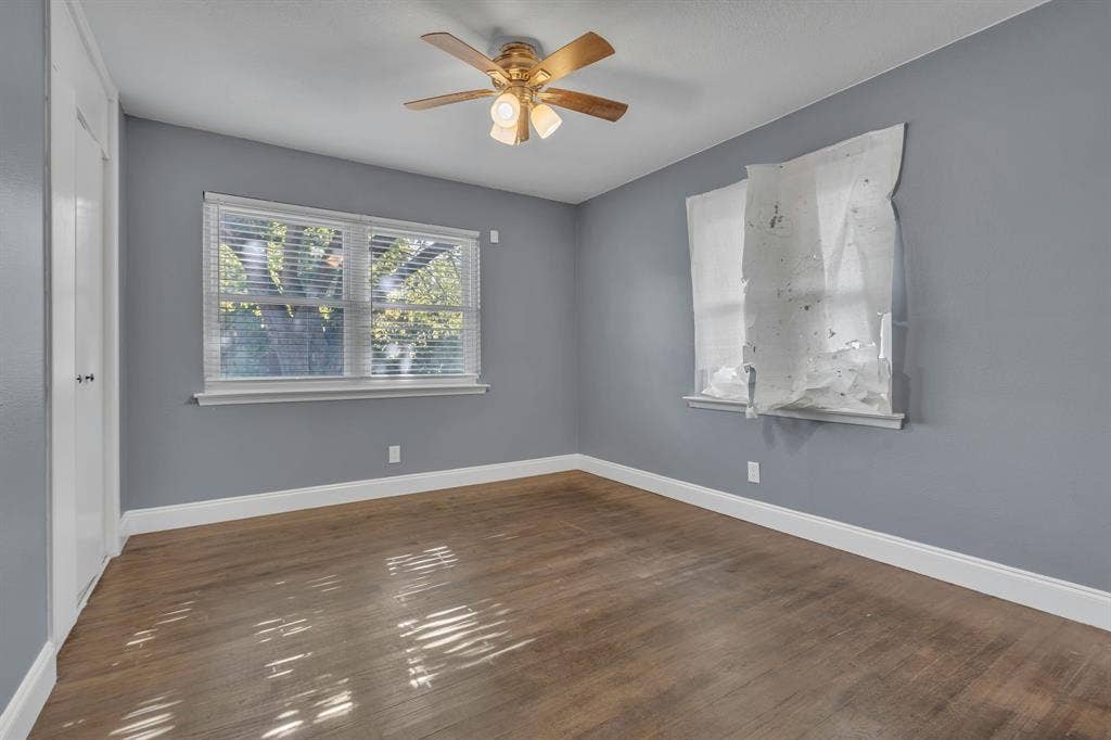 9621 Rustown Drive, Dallas, TX 75228 Wood-finish flooring with light gray walls, white trim, and a ceiling fan