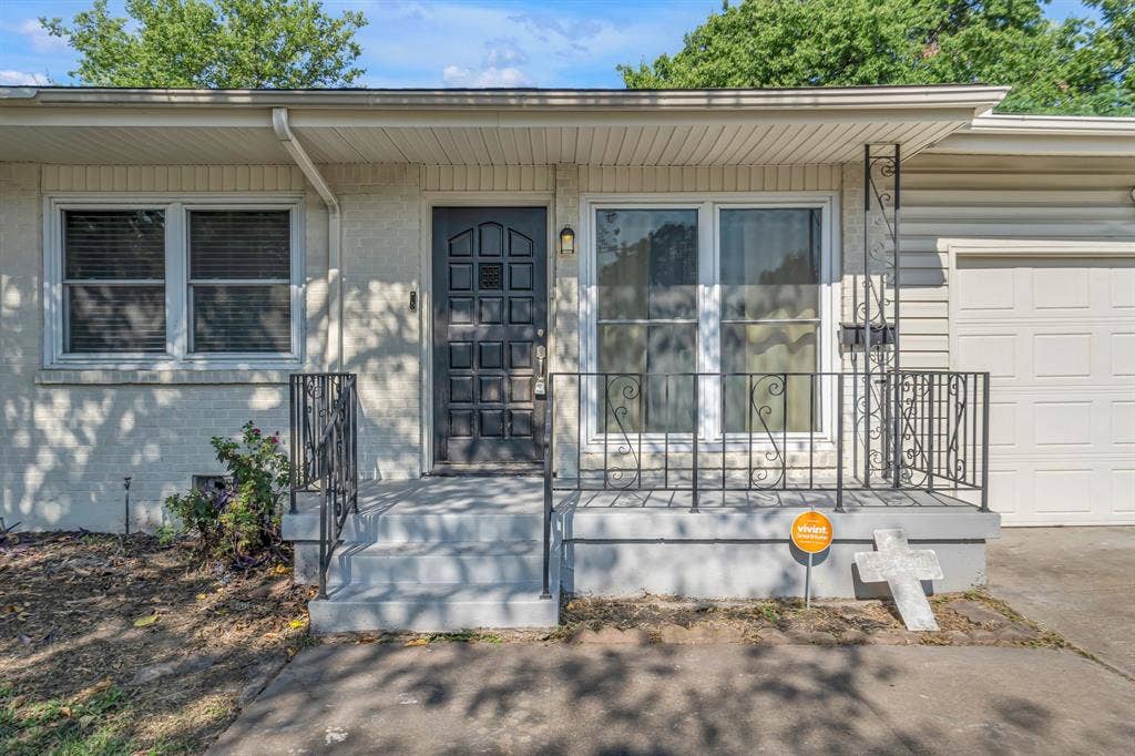 9621 Rustown Drive, Dallas, TX 75228 Front exterior featuring a covered entry, decorative metal railings, a paneled front door, and a single-car garage