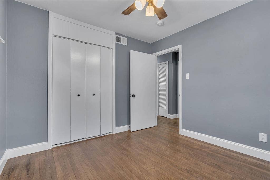 9621 Rustown Drive, Dallas, TX 75228 Wood-finish flooring, white bi-fold closet doors, ceiling fan with integrated lighting, white trim