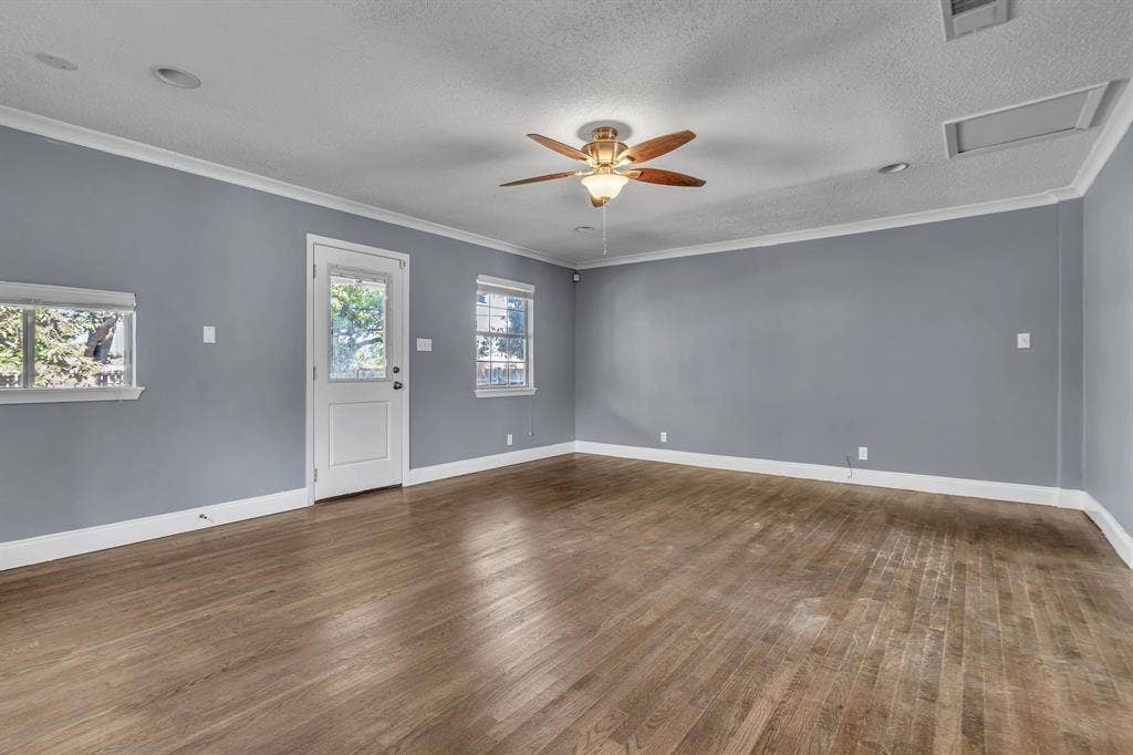 9621 Rustown Drive, Dallas, TX 75228 Hardwood flooring, painted walls, ceiling fan with integrated lighting, multiple windows, and a glass-paneled door