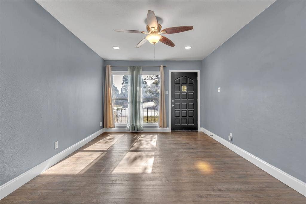 Wood-finish flooring throughout, complemented by a ceiling fan with integrated lighting